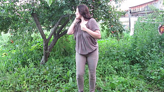 MILF pee in tight pants in a public park open air. Dirty cunt squatting pissing in the yard.