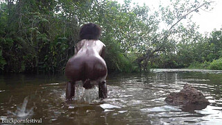 Attractive African village girl bathing in the river