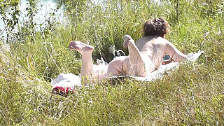 Nude Milf sunbathing on river bank. Random guy watching and filmed on his smartphone. Wild beach. Naked in public. Nudist beach. Doggystyle. Ass. Pussy. Doggy style. POV. Outdoor. Outside. Publicly. Ass milf. Butt. In nature. Without panties. No panties